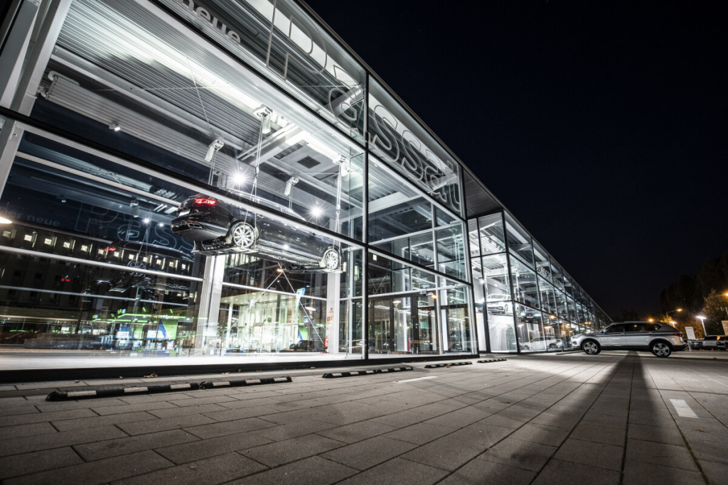 Porsche Showroom in Salzburg bei Nacht, glasfassade mit ausgestellten Fahrzeugen.