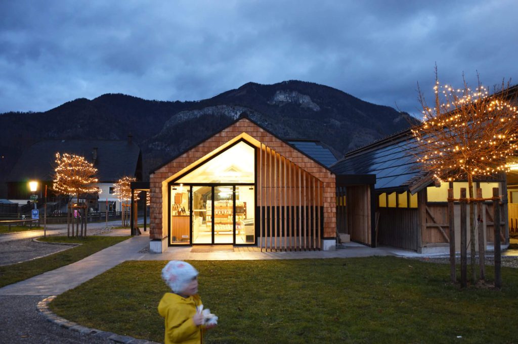 Selbstbedienungs-Hofladen WOLKE7 bei Dämmerung, umgeben von Natur und Lichtern.